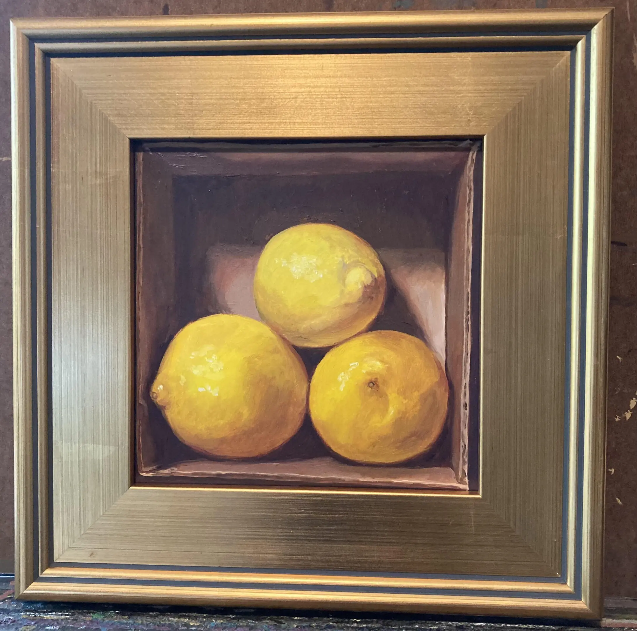 Three lemons in a box on the wall