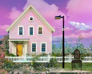 A pink house with a white picket fence and chair.